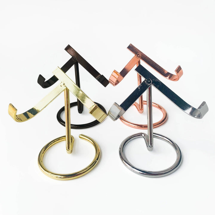 Four metal heart-shaped crystal sphere display stands in black, rose gold, silver, and golden finishes.