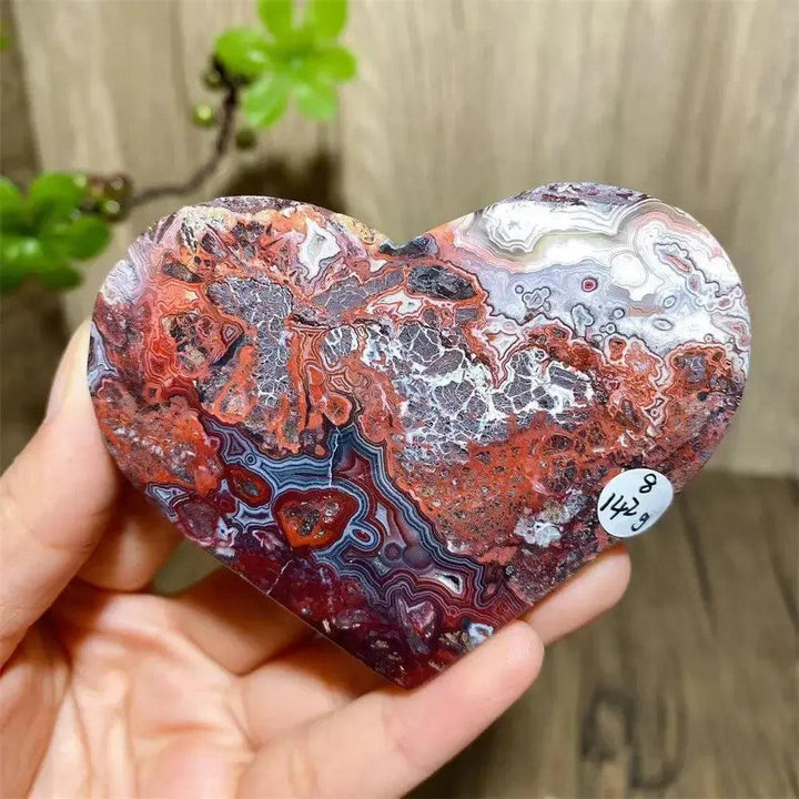Vibrant Mexican Agate crystal heart, banded in red, white, and purple, for joy and emotional balance.
