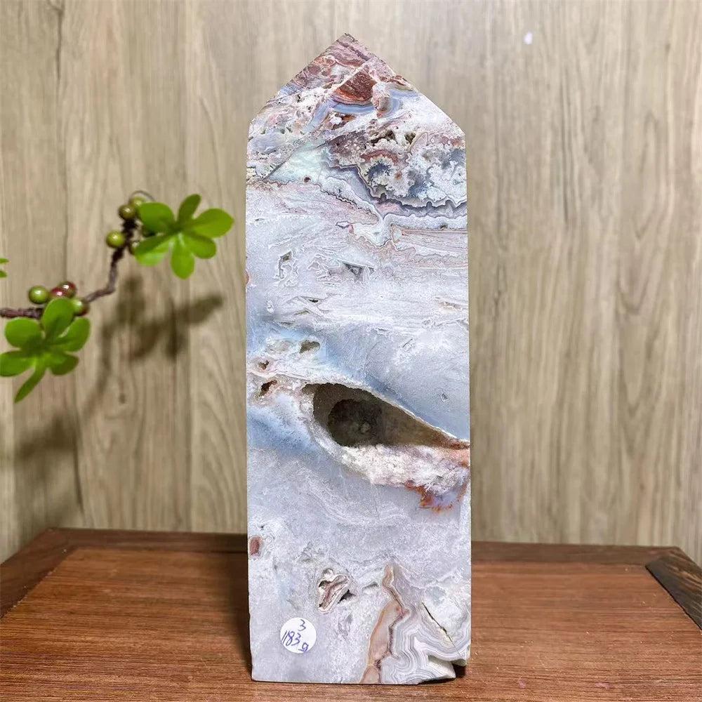 Mexican Agate Crystal Tower: Bold, swirling bands of deep red, cream, and rust with a natural geode opening.