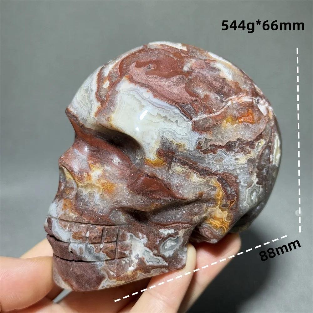 Hand-carved Mexican Agate skull, 88mm, with natural red, white, and brown swirling patterns, for healing and Feng Shui.