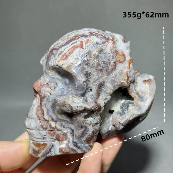 Mexican Agate hand-carved skull, 355g, 80mm, with natural red, white, and gray bands, for healing and meditation.