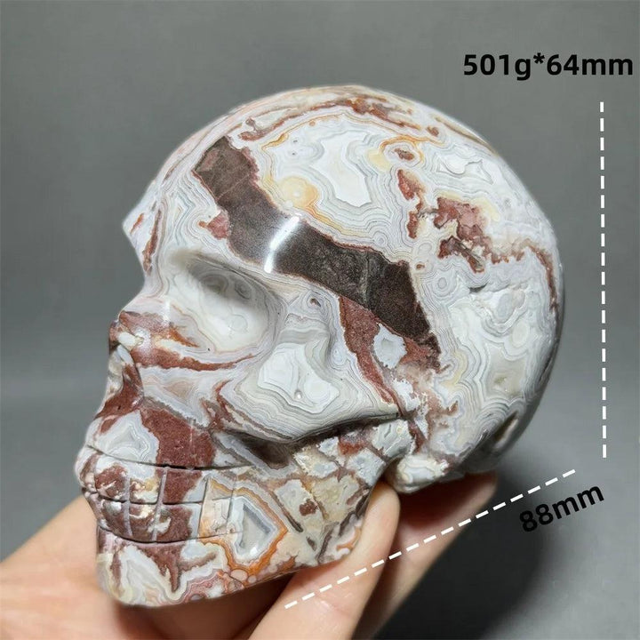 Hand-carved Mexican Agate skull, 88mm, with swirling white, brown, and red patterns for healing and meditation.