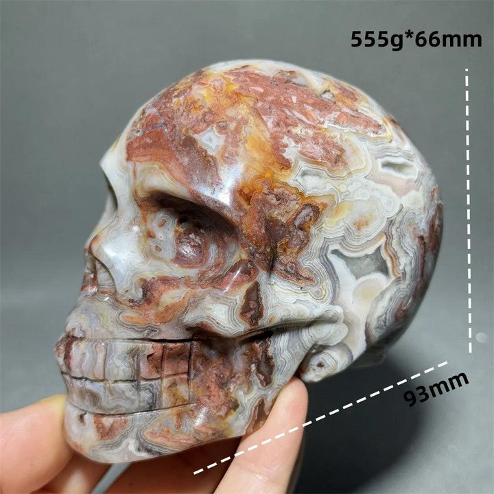 Hand-carved Mexican Agate skull, 93mm, with natural red, orange, and white patterns for healing and meditation.