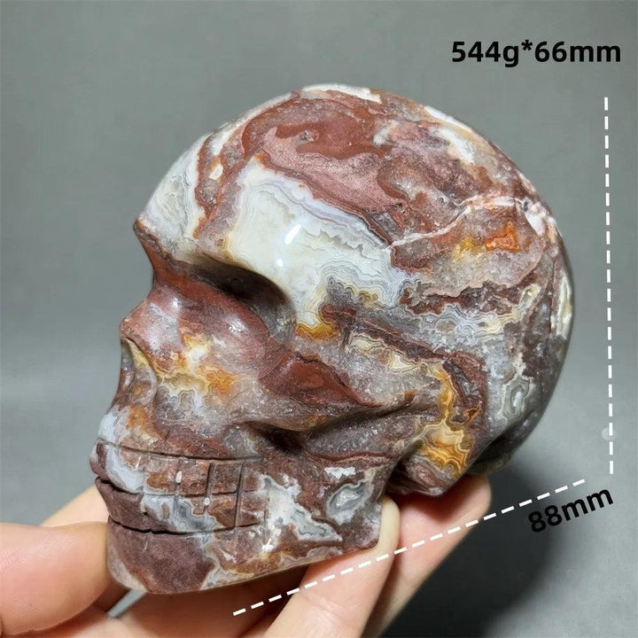 Hand-carved Mexican Agate skull, 88mm, with natural red, white, and brown swirling patterns, for healing and Feng Shui.