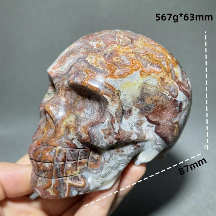 Hand-carved Mexican Agate skull, 87mm, with natural orange, white, and brown patterns for healing and meditation.