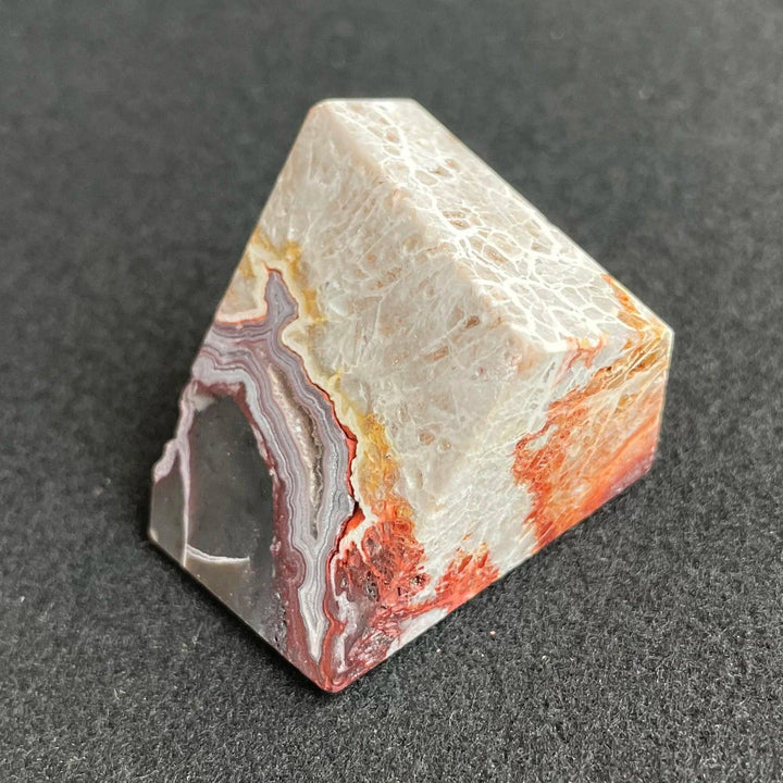 Polished Mexico Agate freeform crystal with vibrant red, white, and grey banding for Reiki healing and home decor.