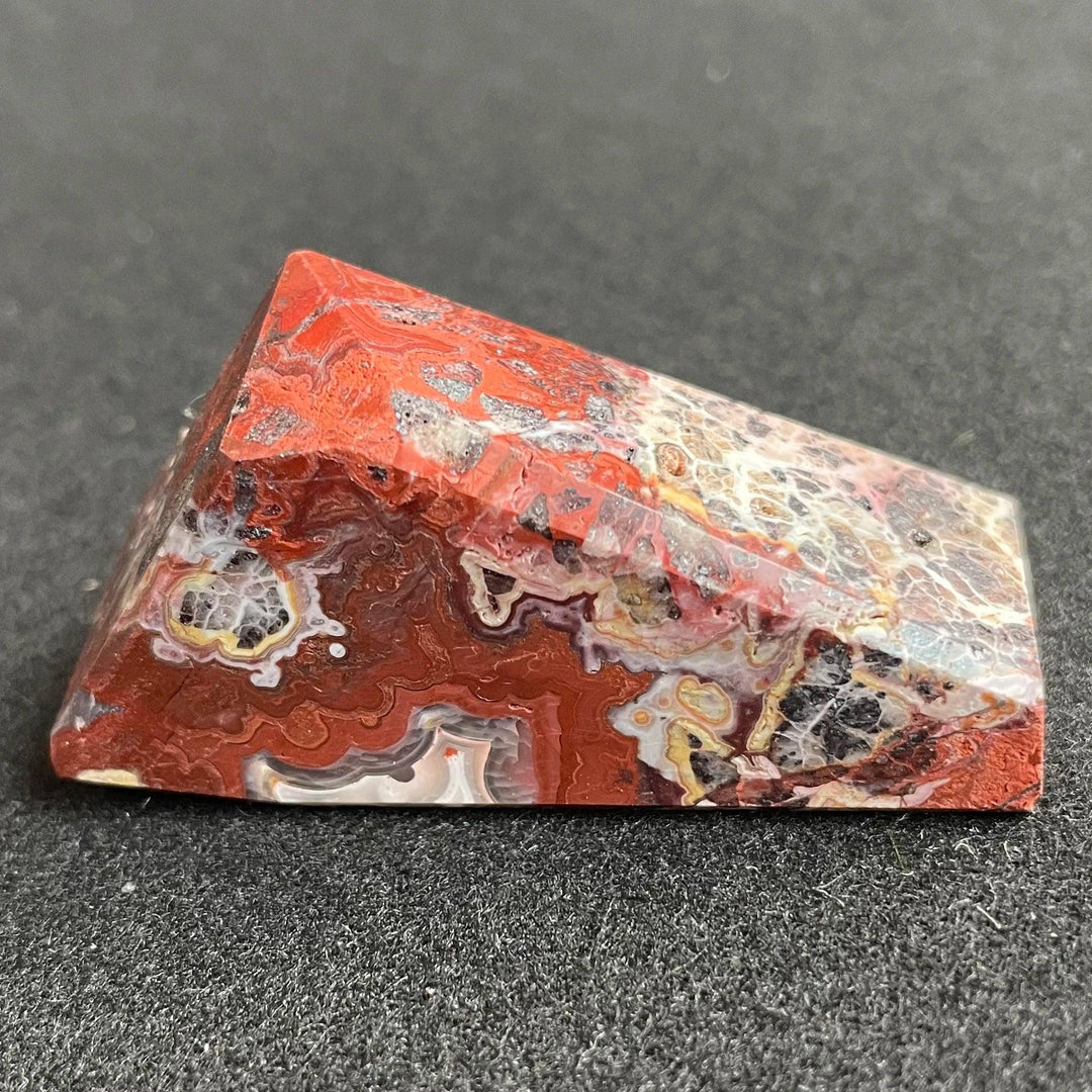 Polished Mexico Agate freeform crystal featuring vibrant red, white, and black patterns for Reiki healing and decor.