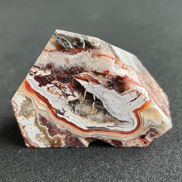 Polished Mexico Agate freeform crystal featuring vibrant red and white banded patterns for Reiki healing and decor.