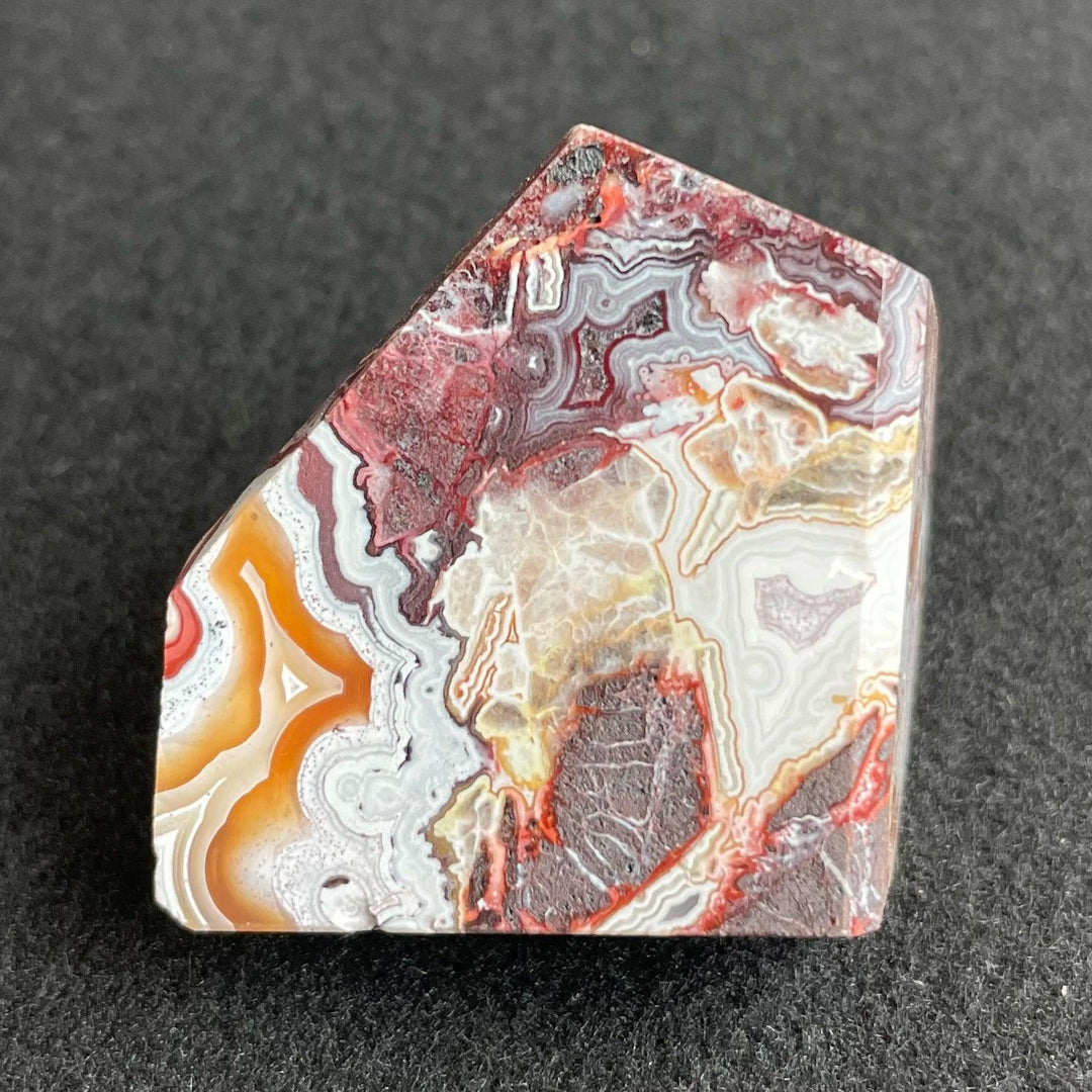 Polished Mexico Agate freeform crystal featuring vibrant red, orange, and white banded patterns for Reiki healing.