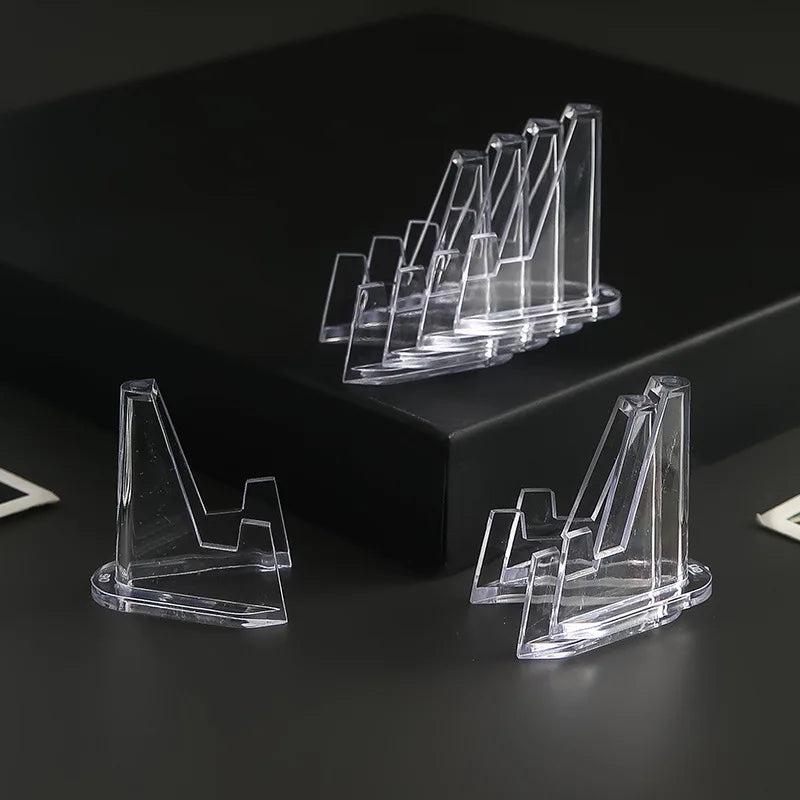 Clear acrylic triangle easel stands for crystals, shown in various sizes on a dark surface.