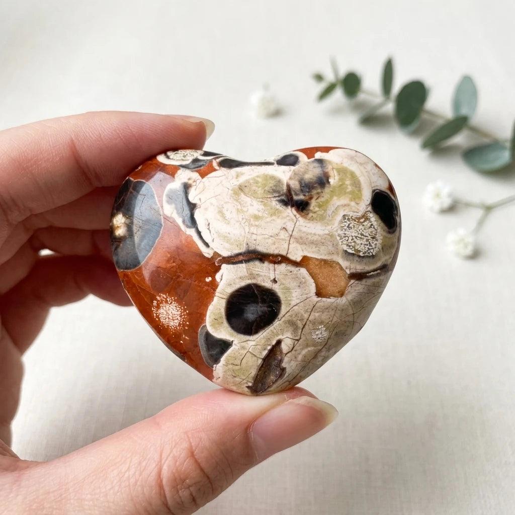 Polished Natural Money Agate heart crystal with unique red, cream, and black patterns for elegant home decor and healing.