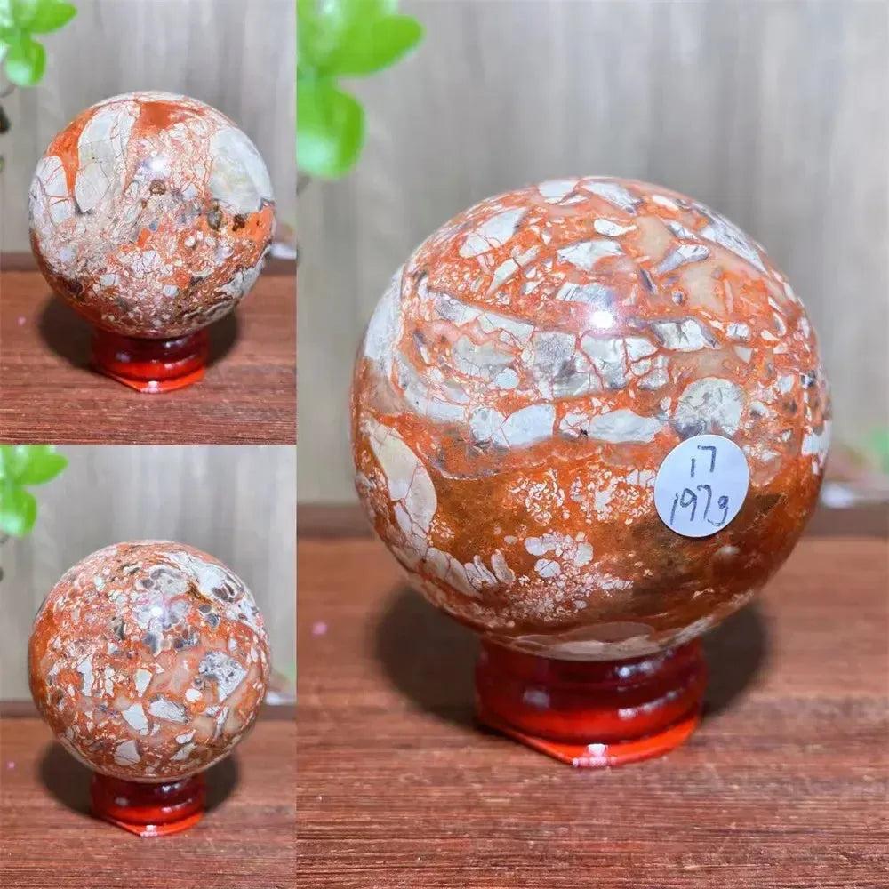 Polished Money Agate Crystal Sphere, a vibrant abundance stone with gold, rust, and cream banding, on a red stand.