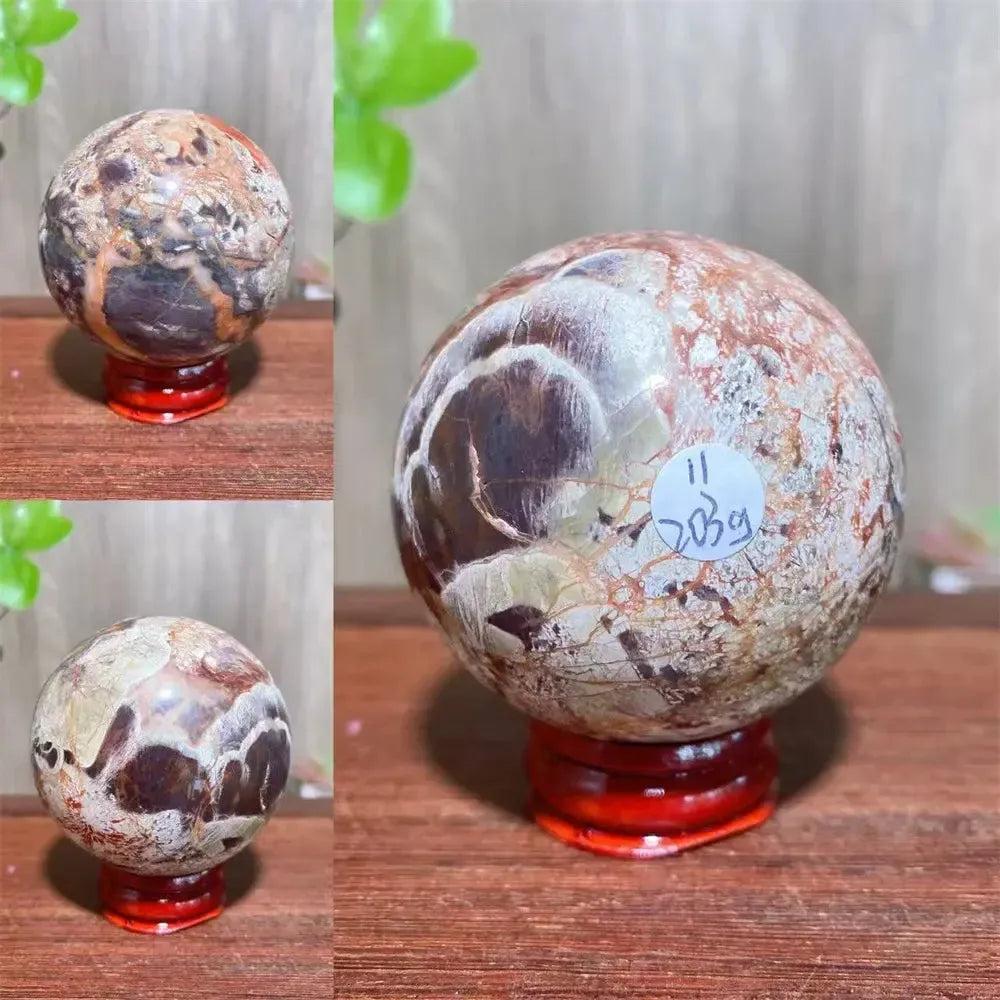 Polished Money Agate Crystal Sphere, a beautiful abundance stone with gold, rust, and cream banding on a red stand.