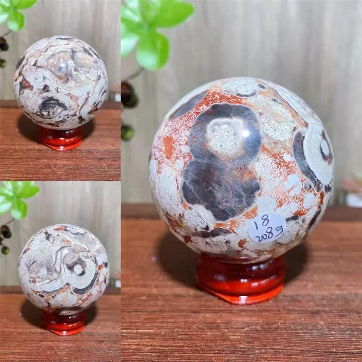 Polished Money Agate Crystal Sphere, a unique abundance stone with vibrant gold, rust, and cream banding on a red stand.