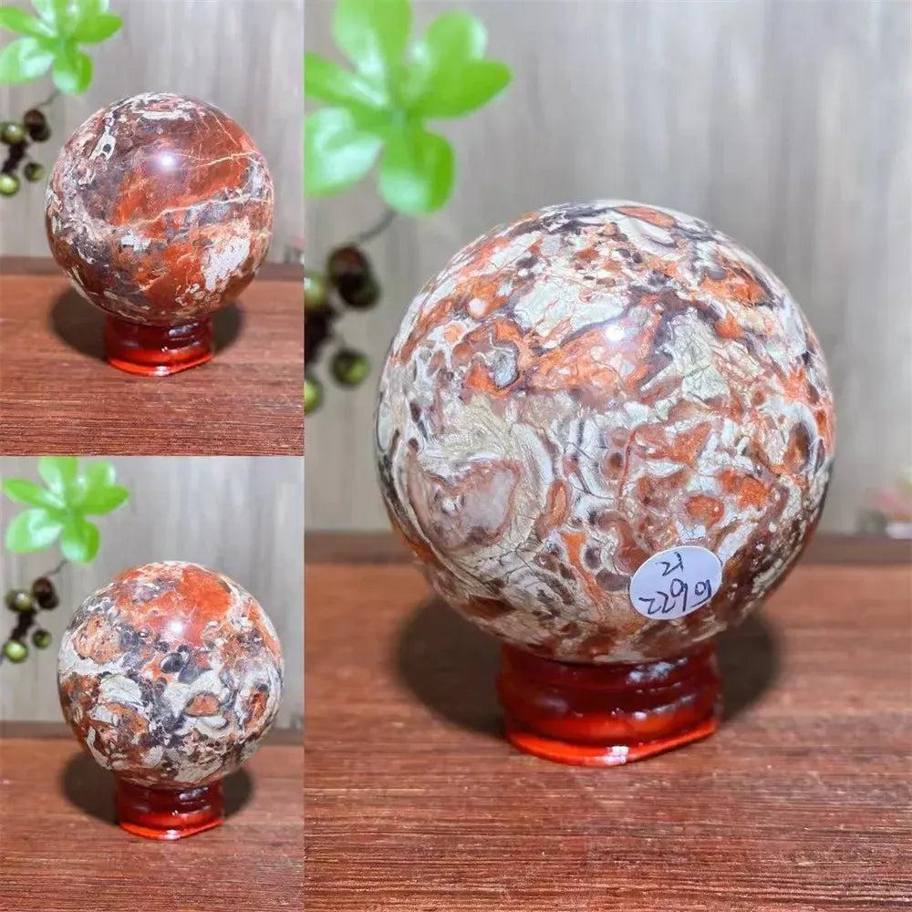 Polished Money Agate Crystal Sphere, a unique abundance stone with vibrant gold, rust, and cream banding on a red stand.