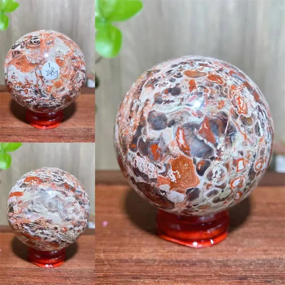 Polished Money Agate Crystal Sphere, a vibrant abundance stone with gold, rust, cream, and warm brown banding on a red stand.