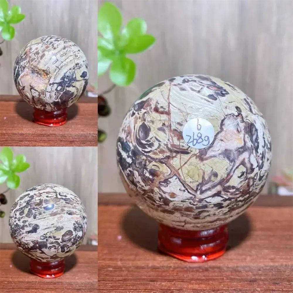 Polished Money Agate Crystal Sphere, a unique abundance stone with gold, rust, and cream banding on a red stand.