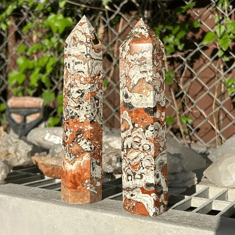 Two Money Agate Crystal Towers with earthy orange, white, and black patterns for grounding and abundance.