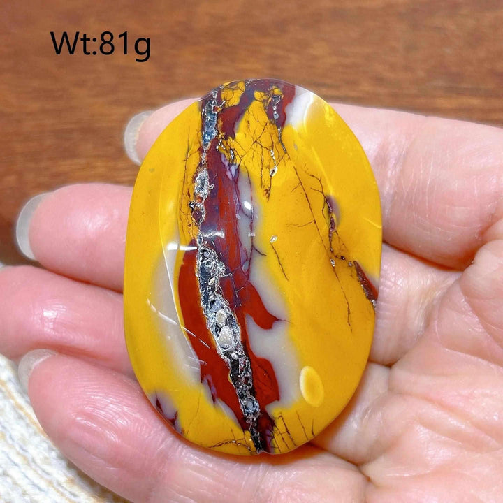 Smooth 81g Mookaite Jasper palm stone featuring vibrant red, yellow, and cream swirls for grounding and vitality.