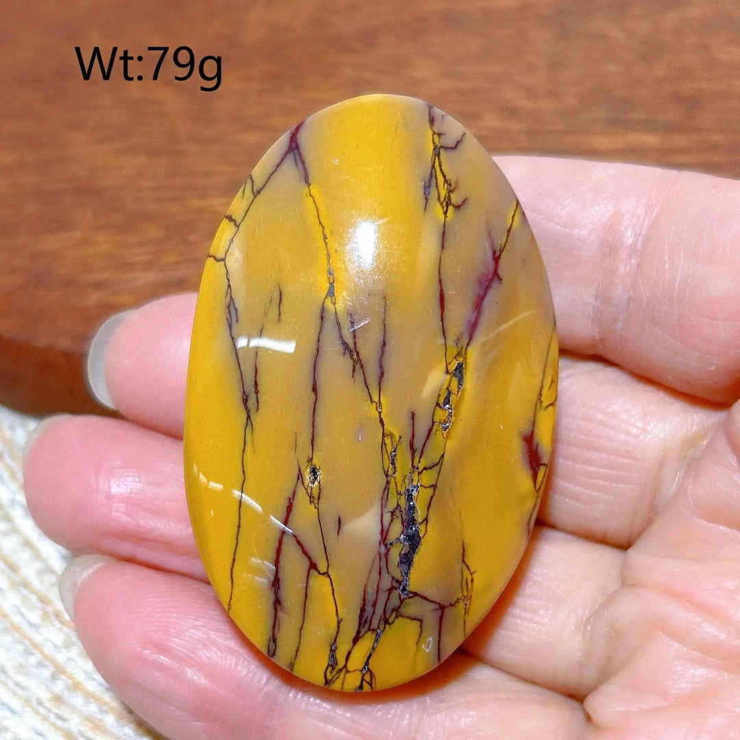 Smooth, 79g Mookaite Jasper palm stone featuring vibrant mustard yellow and red veins for grounding and vitality.