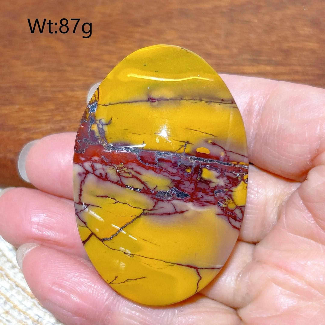 Smooth 87g Mookaite Jasper palm stone featuring vibrant mustard yellow and deep red swirls for grounding energy.