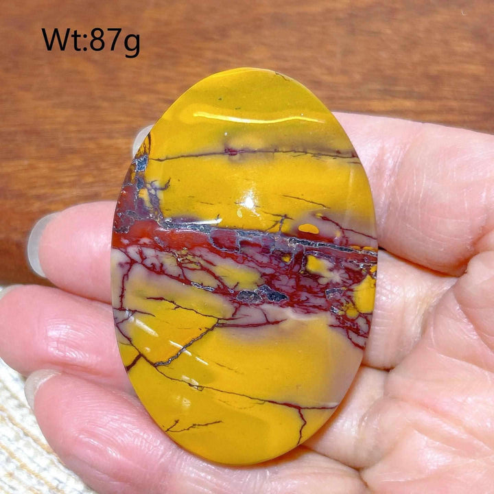 Smooth 87g Mookaite Jasper palm stone featuring vibrant mustard yellow and deep red swirls for grounding energy.