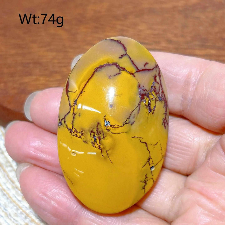 Smooth 74g Mookaite Jasper palm stone featuring vibrant mustard yellow and deep red veins for grounding energy.