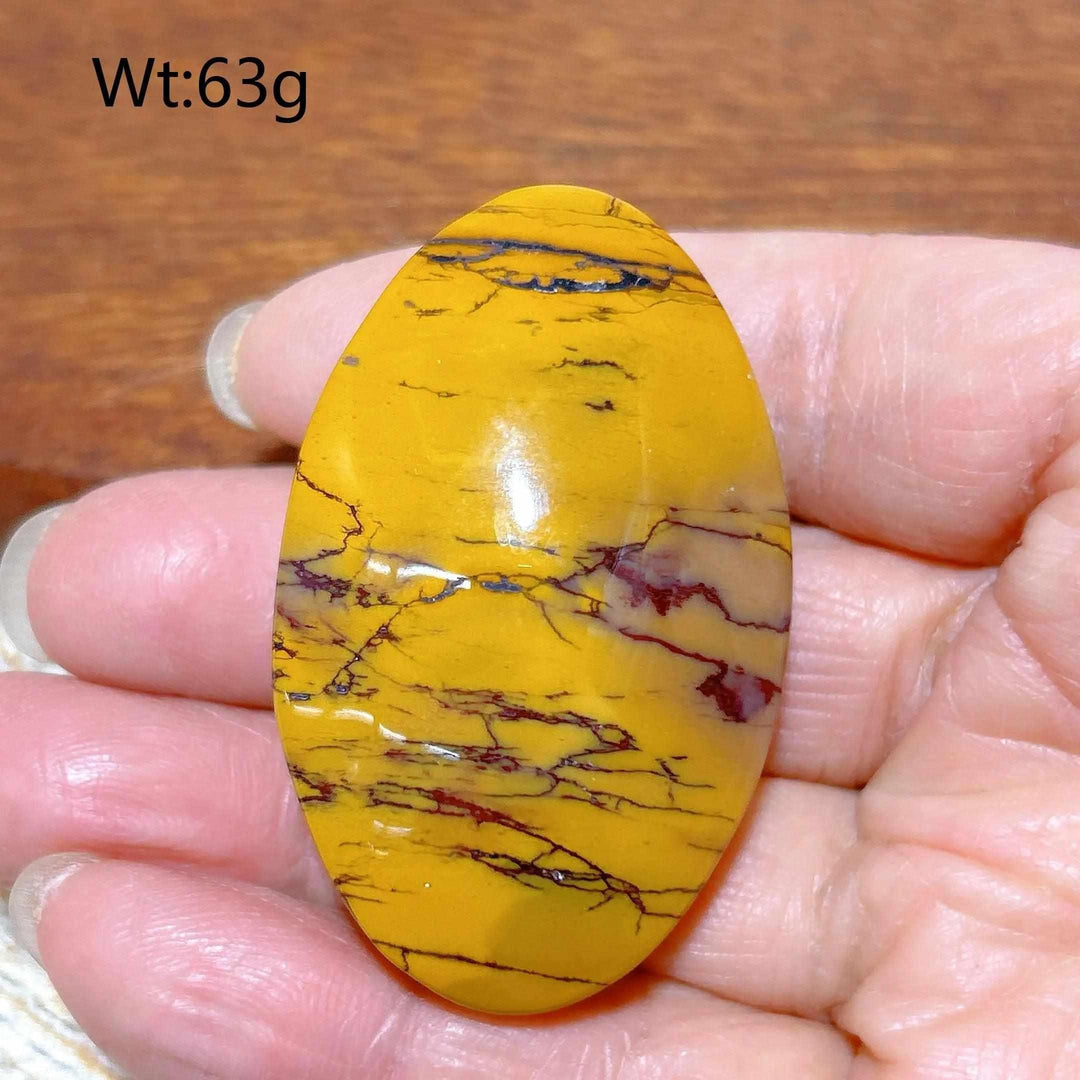 Smooth 63g Mookaite Jasper palm stone featuring vibrant mustard yellow and red earthy swirls for grounding energy.