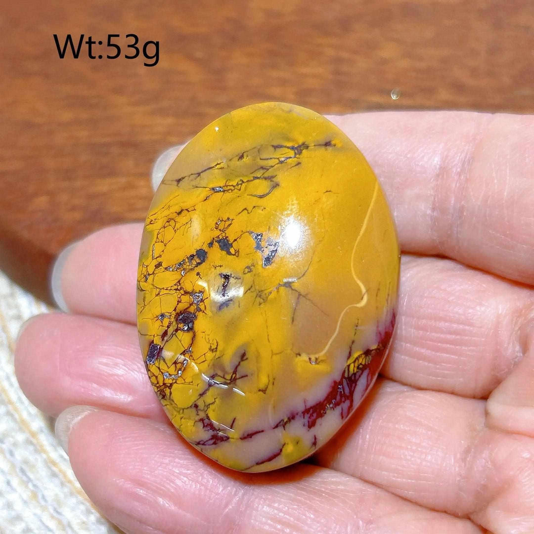 Smooth 53g Mookaite Jasper palm stone with vibrant mustard yellow, red, and cream swirls for grounding and vitality.