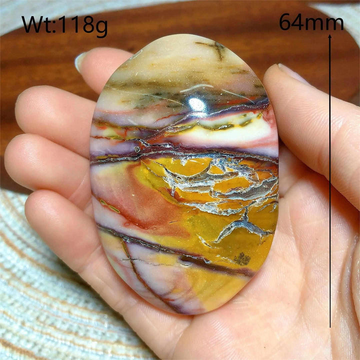 Smooth 64mm Mookaite Jasper palm stone featuring vibrant swirls of red, yellow, cream, and mauve for grounding energy.