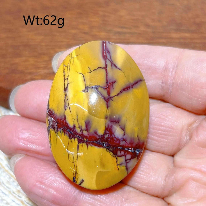 Smooth 62g Mookaite Jasper palm stone featuring vibrant mustard yellow and deep red swirls for grounding energy.
