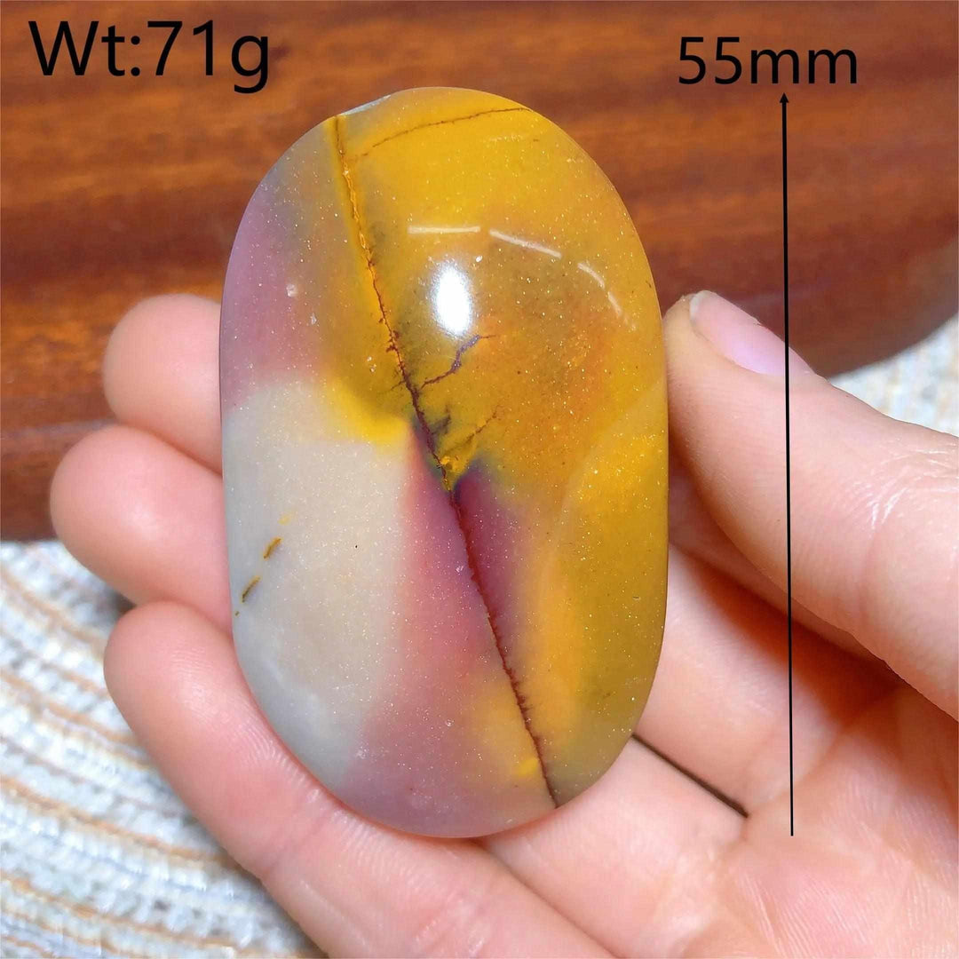 Smooth 55mm Mookaite Jasper palm stone featuring vibrant red, yellow, and mauve swirls for grounding and vitality.