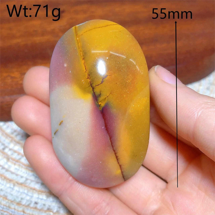 Smooth 55mm Mookaite Jasper palm stone featuring vibrant red, yellow, and mauve swirls for grounding and vitality.