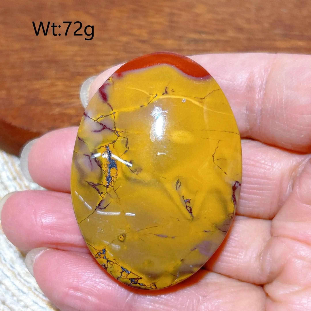 Smooth 72g Mookaite Jasper palm stone featuring vibrant mustard yellow, red, and cream swirls for grounding and vitality.