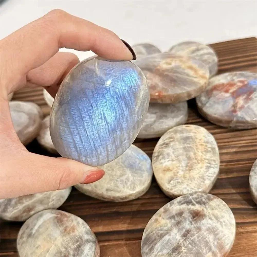 Hand-polished natural blue flash moonstone palm stone with a smooth, healing crystal surface perfect for meditation.
