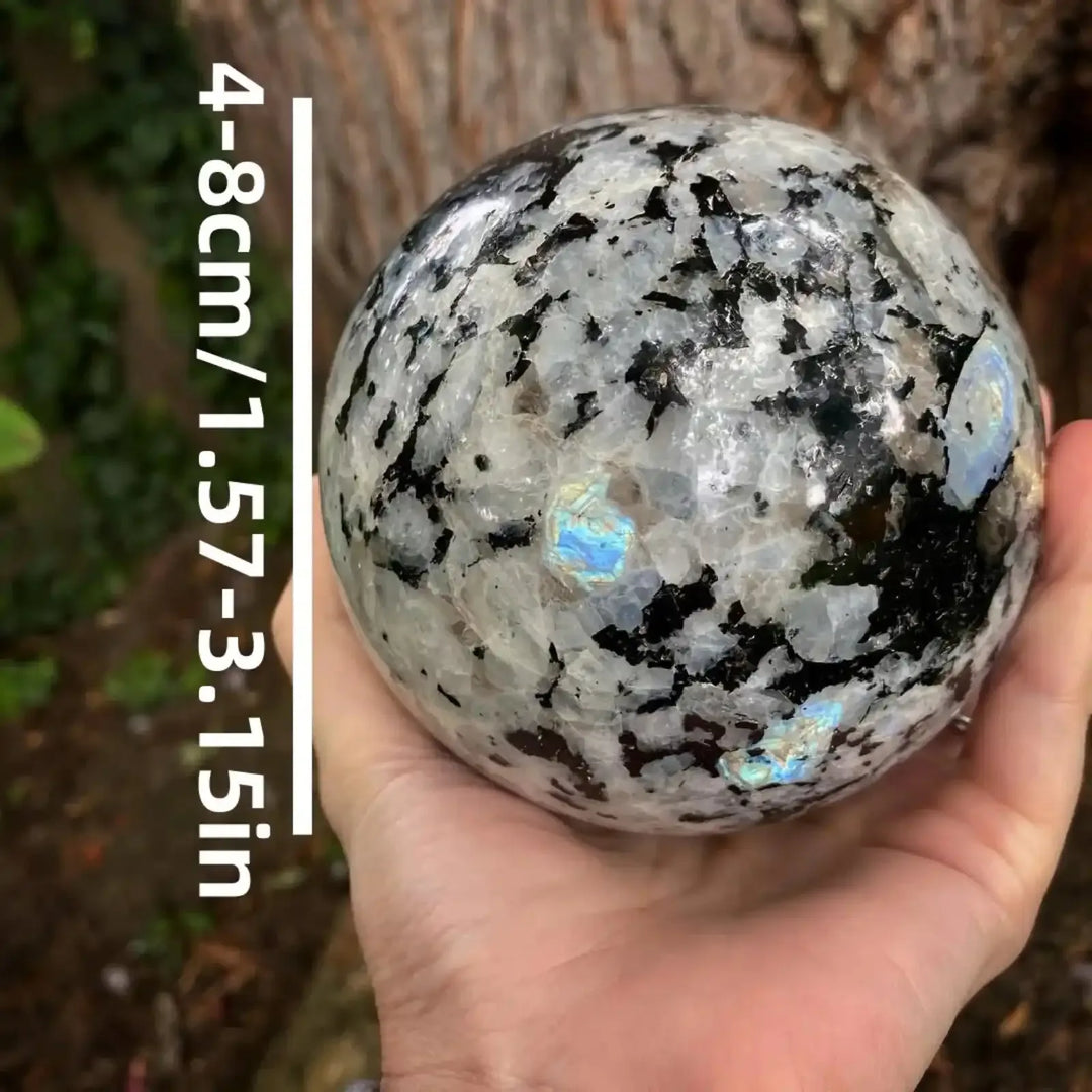 Polished Moonstone sphere featuring black inclusions and iridescent blue flashes, 4-8cm crystal ball for home decor.