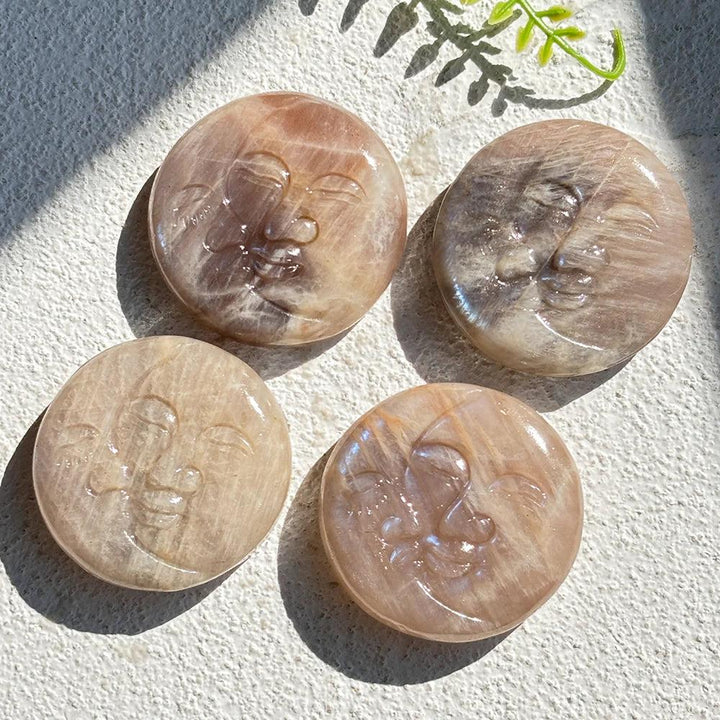 Four pearlescent Moonstone Crystal Sun and Moon Face Carvings, radiating soft glow and intuitive energy.
