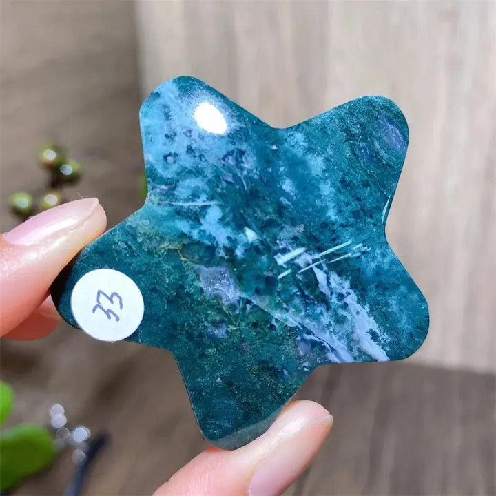 Hand-carved moss agate star crystal carving, showcasing deep green inclusions and white veins, for new beginnings.