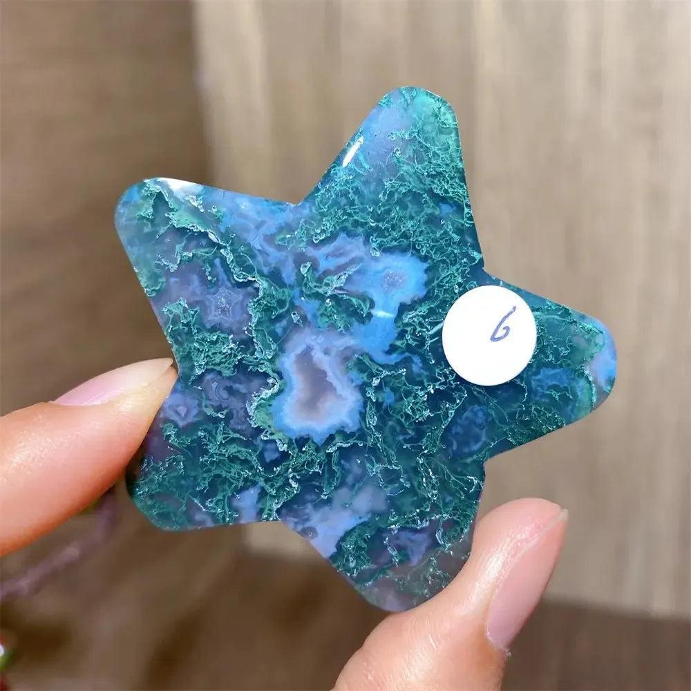 Natural Moss Agate Star Crystal Carving, a deep green healing stone with blue inclusions, held in hand.