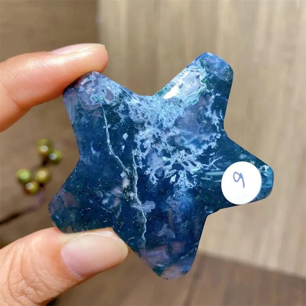 Hand-carved moss agate star crystal with deep green and blue inclusions, symbolizing new beginnings and abundance.