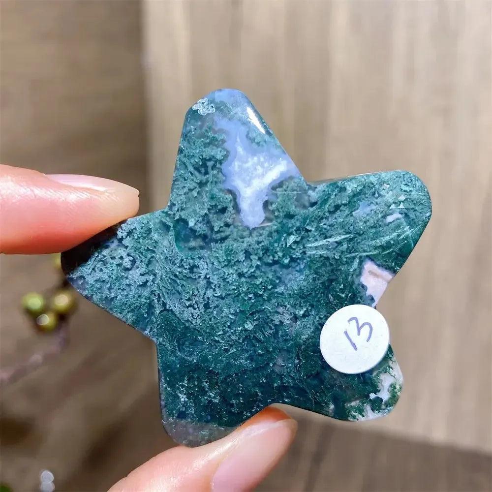 Moss Agate Star Crystal Carving, a natural green healing stone with deep green inclusions, held by fingers.