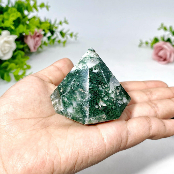 Moss Agate crystal, polished diamond shape, held in a hand, showcasing green dendritic inclusions.