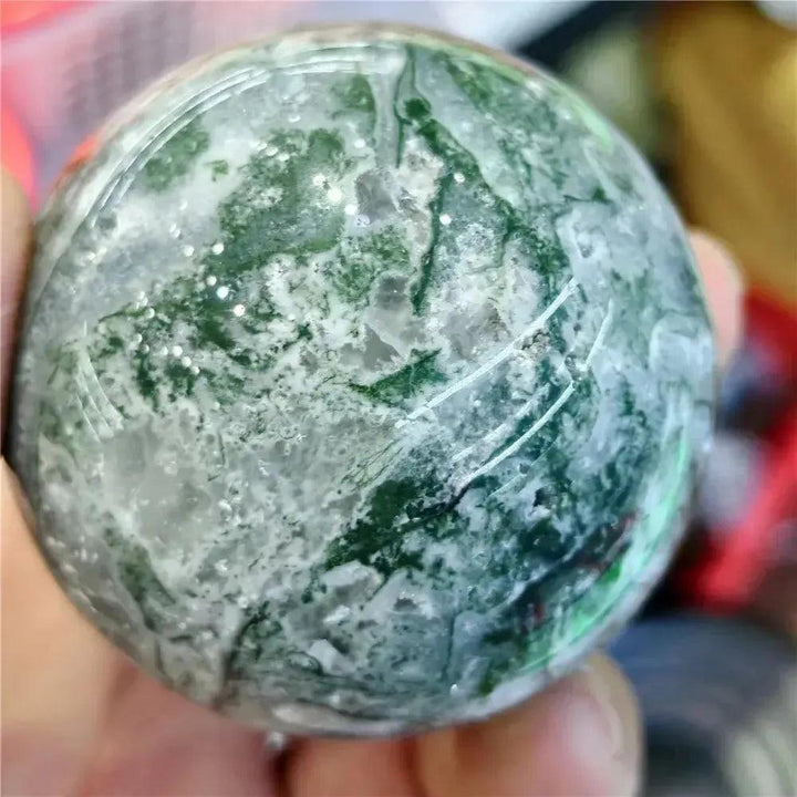 Moss Agate Sphere: Hand-polished, translucent chalcedony sphere with vibrant green moss-like inclusions.