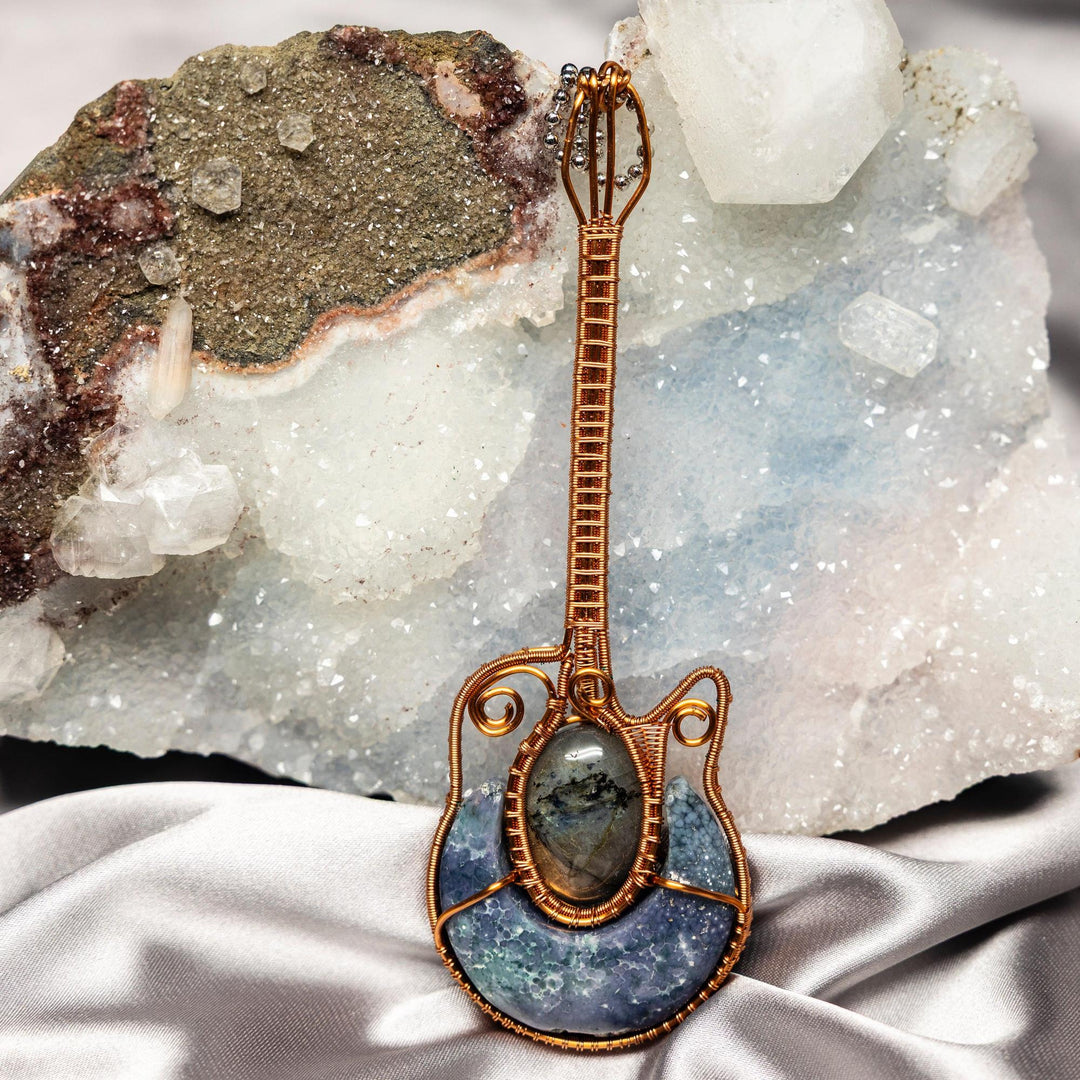 Handcrafted copper wire bass guitar pendant with genuine Moss Agate and Labradorite crystals.