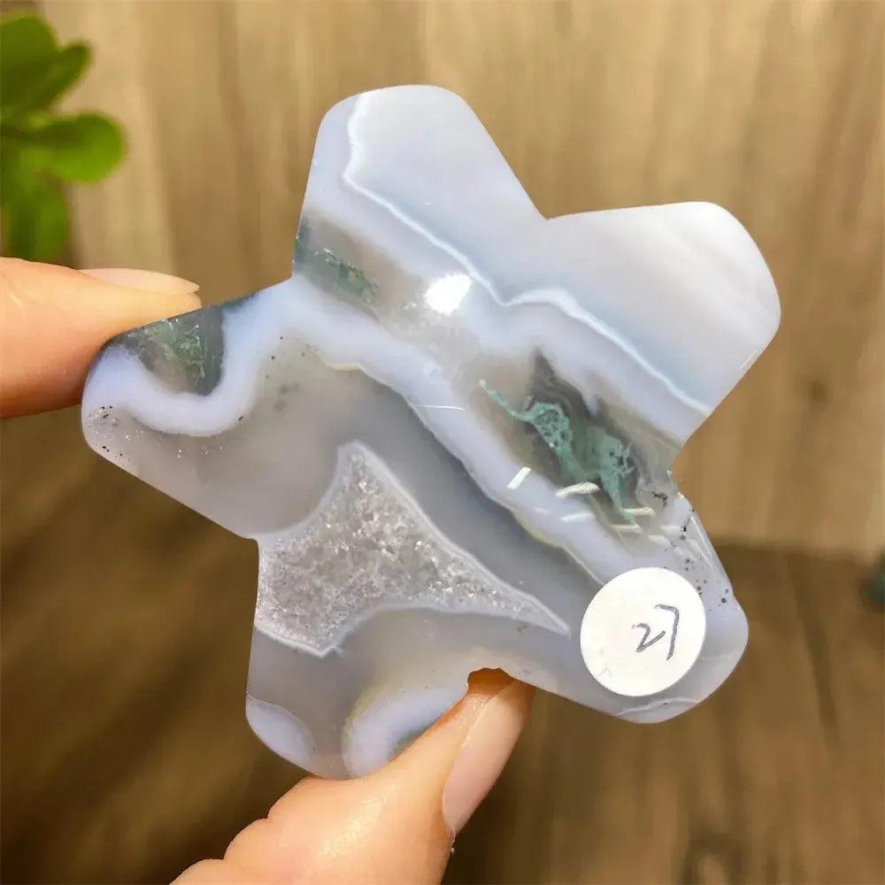 Hand-carved moss agate star from Crystal Destiny, featuring white, gray, and green inclusions with a small geode.