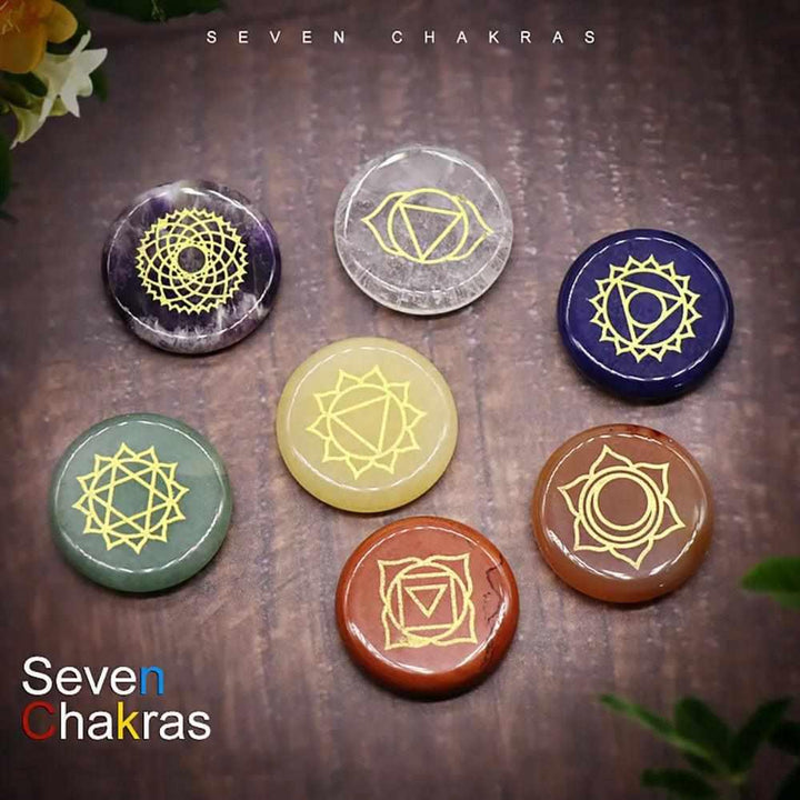 Seven Chakra engraved crystal coins for energy healing, featuring polished stones with gold symbols for meditation.