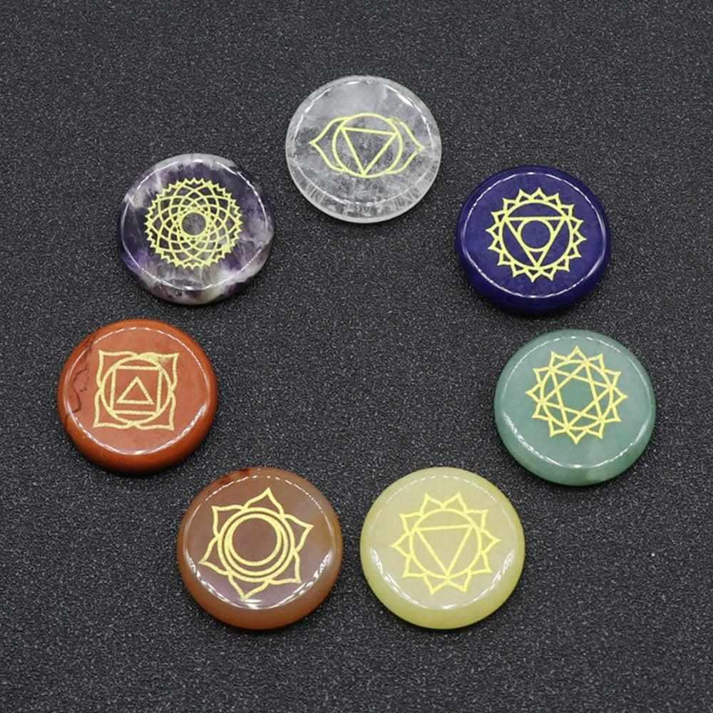 Seven 25mm polished crystal coins engraved with gold chakra symbols for meditation, energy balancing, and healing.