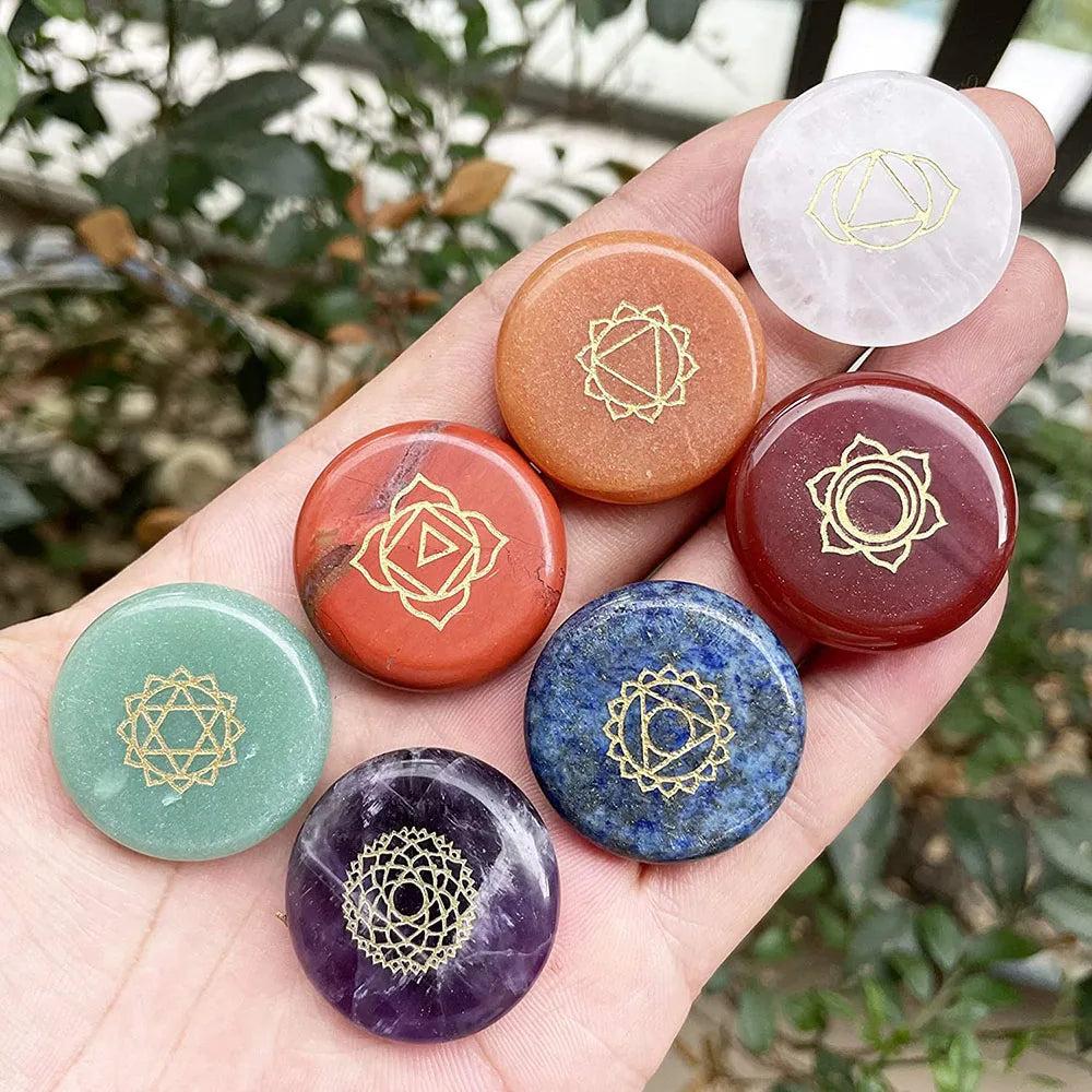 Seven 25mm engraved chakra crystal coins for meditation, featuring polished stones representing each energy center.