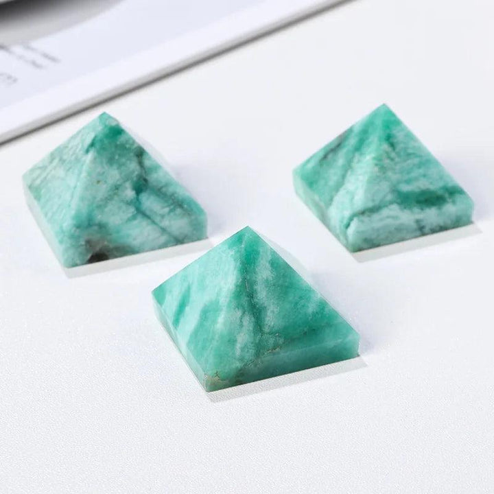 Three natural amazonite crystal pyramids in varying blue-green hues for healing and calm.