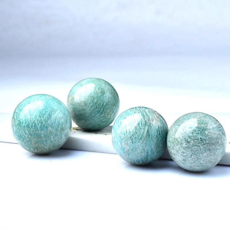 Four polished Natural Amazonite Crystal Spheres, showcasing their calming sky blue-green color and natural mineral patterns.